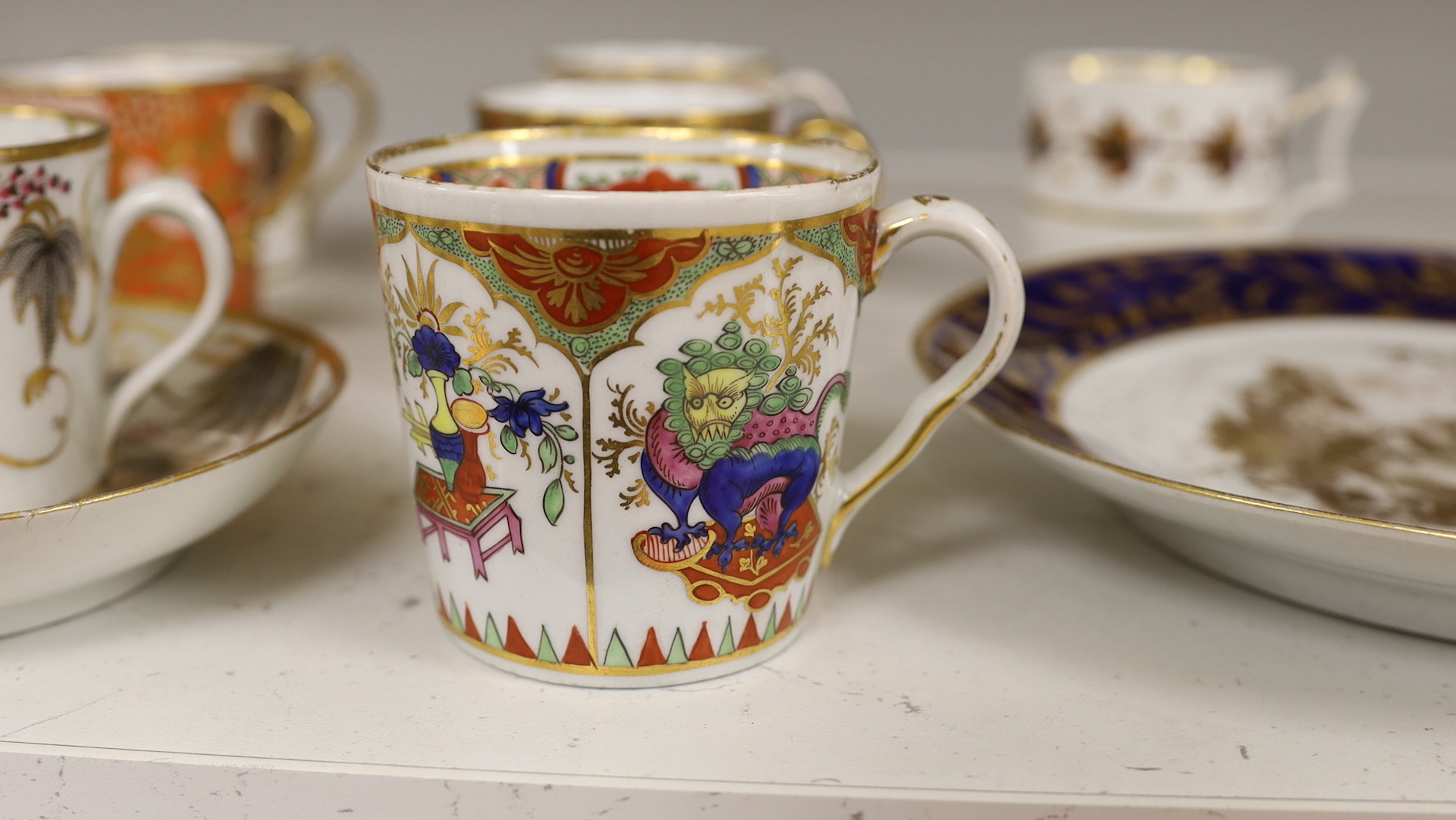 English porcelain coffee cans including Worcester, Spode, Wolfe Mason, Derby and Chamberlain, two New hall cans and saucers and a New hall Warburton’s Patent saucer dish, the largest 20cm in diameter